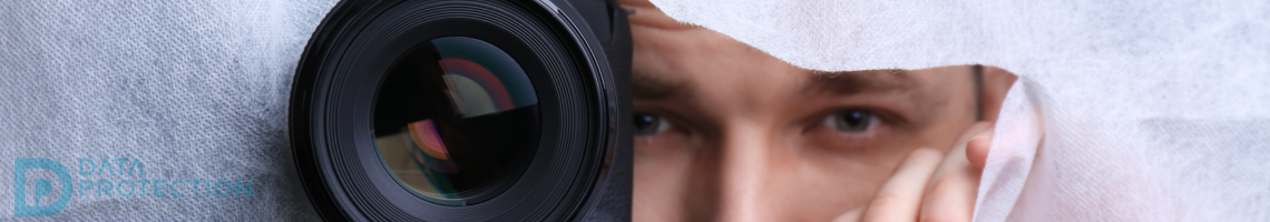 Camera with man behind a piece of material poking through