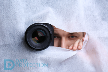 Camera with man behind a piece of material poking through