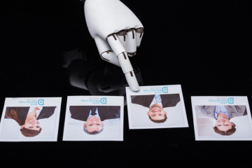 photo of a robot hand choosing a Data Protection Education candidate from four photos, of two ladies and two men